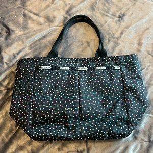 Small black lesportsac handbag with matching small cosmetic bag in star print